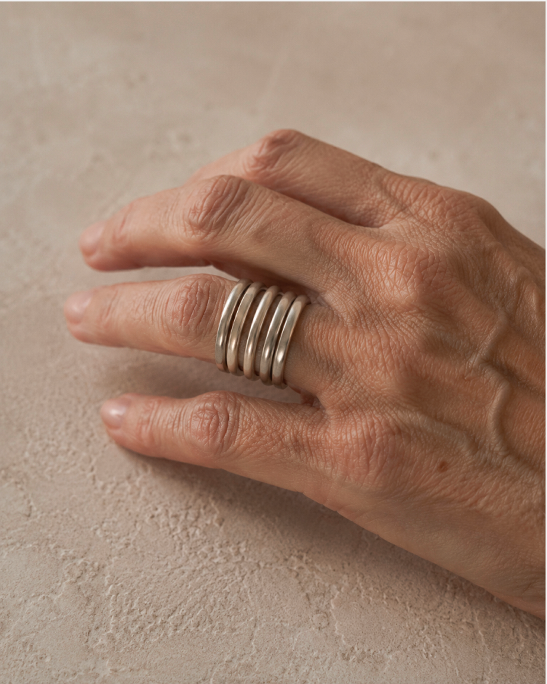 Multiple silver rings worn on a hand